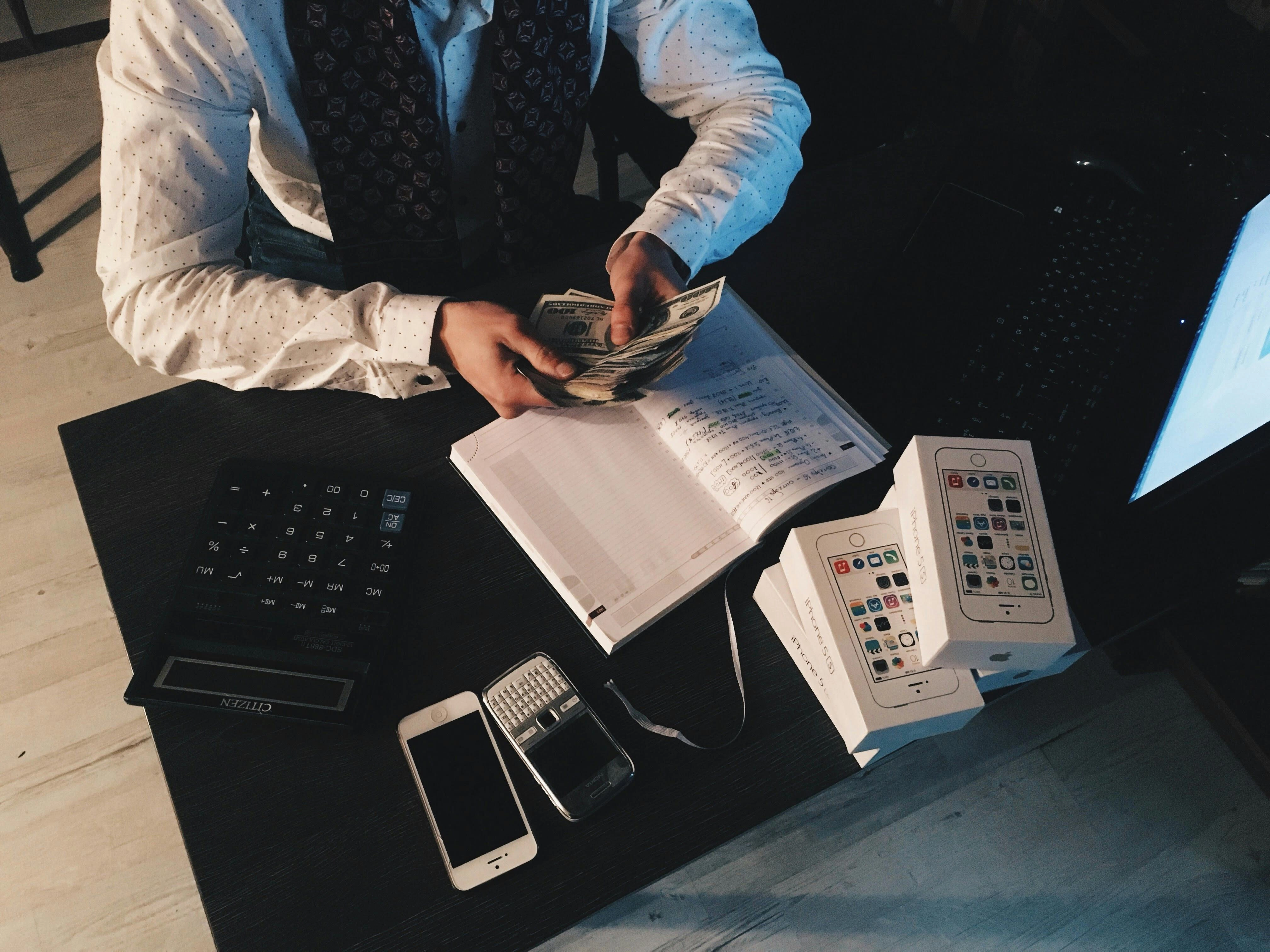 季配息ETF-穿著西裝的男人在書桌上算錢、記帳